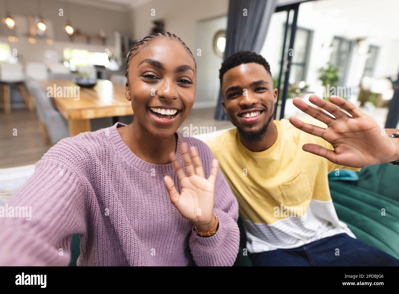 Happy african american couple sitting on sofa and having video call in ...