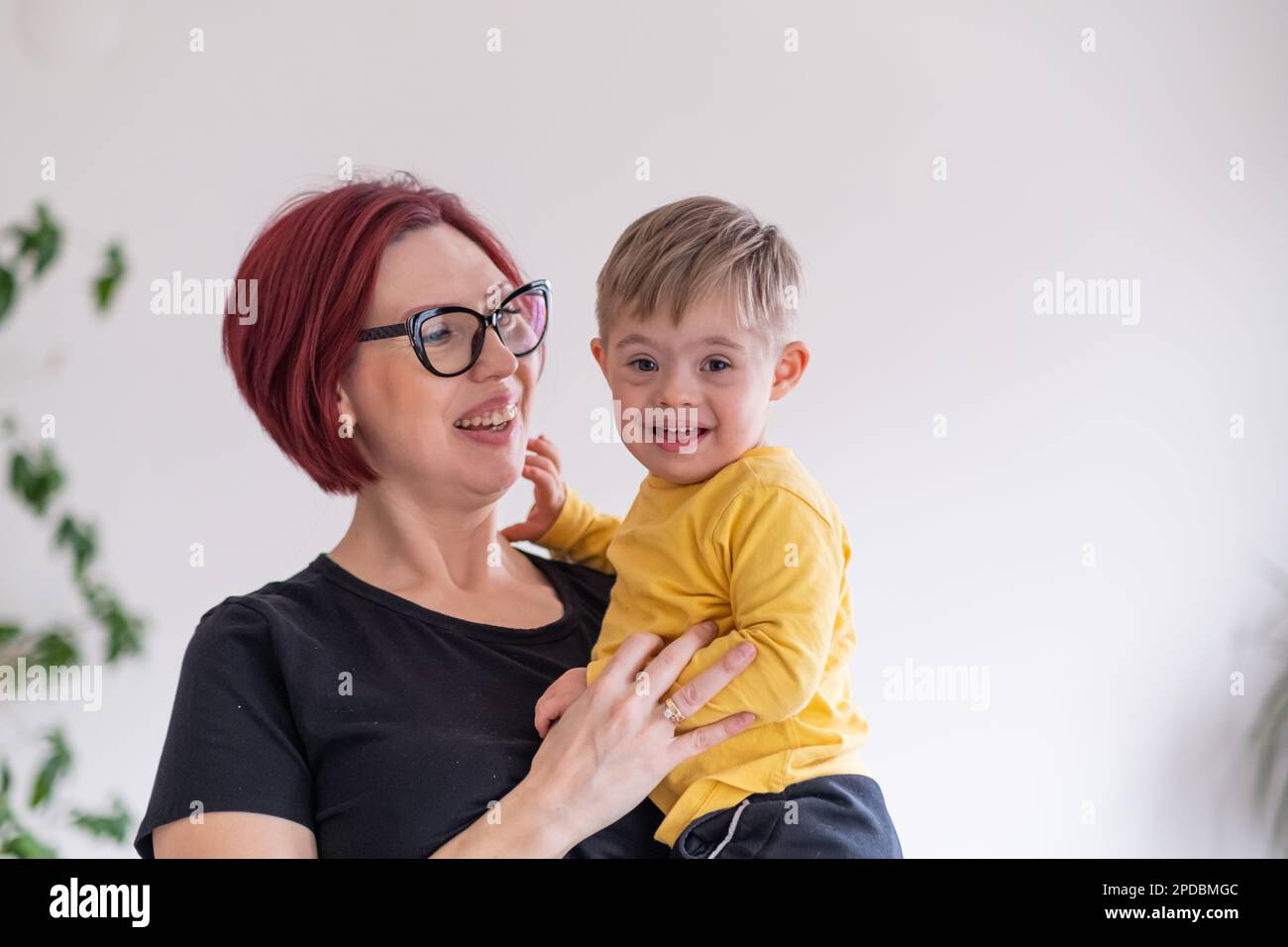 portrait of happy smiling mother and child living with down syndrome having fun. family moments. Stock Photo