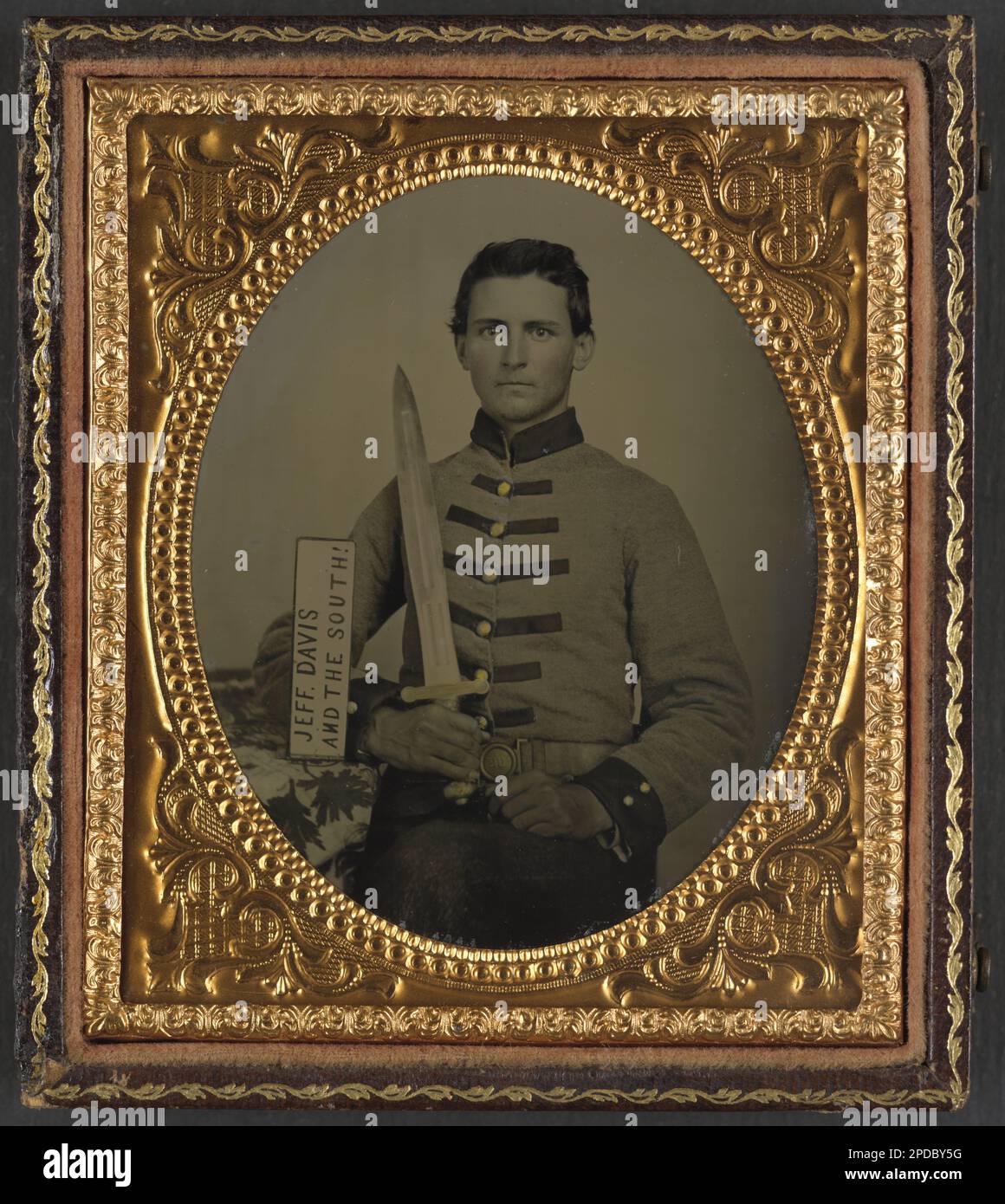Private Henry Augustus Moore of Co. F, 15th Mississippi Infantry Regiment, with artillery short sword and sign reading Jeff Davis and the South!. Liljenquist Family Collection of Civil War Photographs , FAmbrotype/Tintype photograph filing series , Published in: Wynne, Ben. A hard trip: A history of the 15th Mississippi Infantry, CSA. Macon, Georgia: Mercer University Press, 2003, p. xvi, pp/liljconfed. Moore, Henry Augustus, 1827-1862, Confederate States of America, Army, Mississippi Infantry Regiment, 15th, People, 1860-1870, Soldiers, Confederate, 1860-1870, Military uniforms, Confederate, Stock Photo
