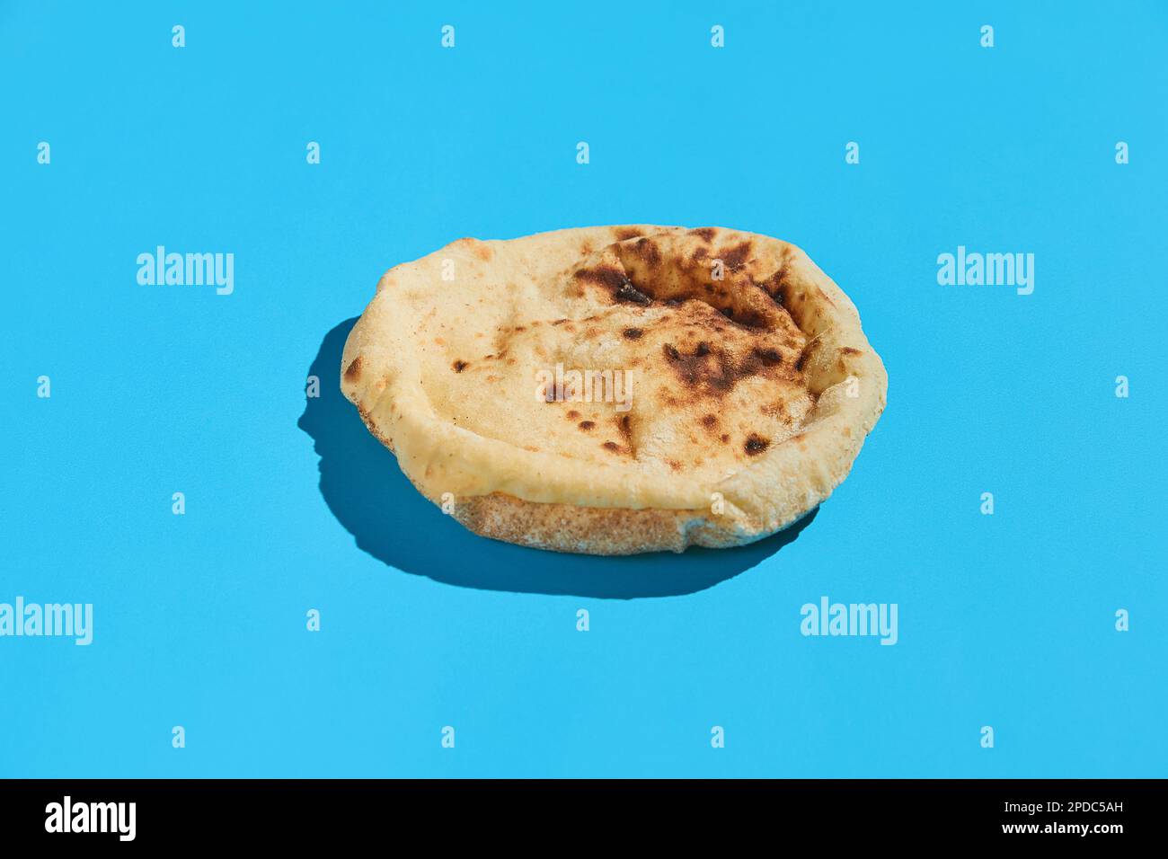 Egyptian bread Aish Baladi. Fresh bread lies on the blue table Stock Photo