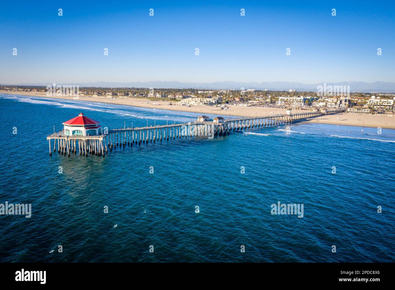 Aerial above the Pacific Ocean looking at the pier at Huntington Beach
