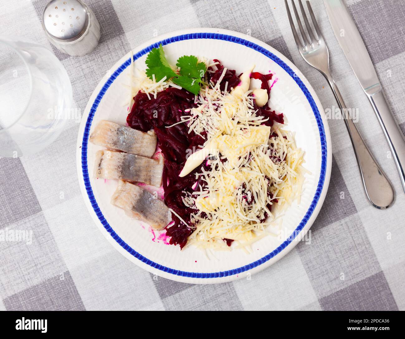 Pieces of chopped herring with beet and cheese served on plate Stock