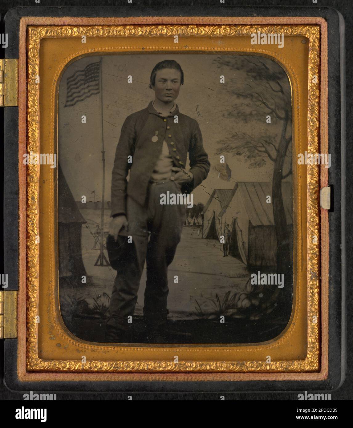 Private Henry Baker of Co. H, 141st Pennsylvania Infantry Regiment in uniform in front of painted backdrop showing military camp. Liljenquist Family Collection of Civil War Photographs , FAmbrotype/Tintype photograph filing series , pp/liljunion. Baker, William, 1844-1941, United States, Army, Pennsylvania Infantry Regiment, 141st (1862-1865), People, Soldiers, Union, 1860-1870, Military uniforms, Union, 1860-1870, Backdrops, 1860-1870, United States, History, Civil War, 1861-1865, Military personnel, Union. Stock Photo