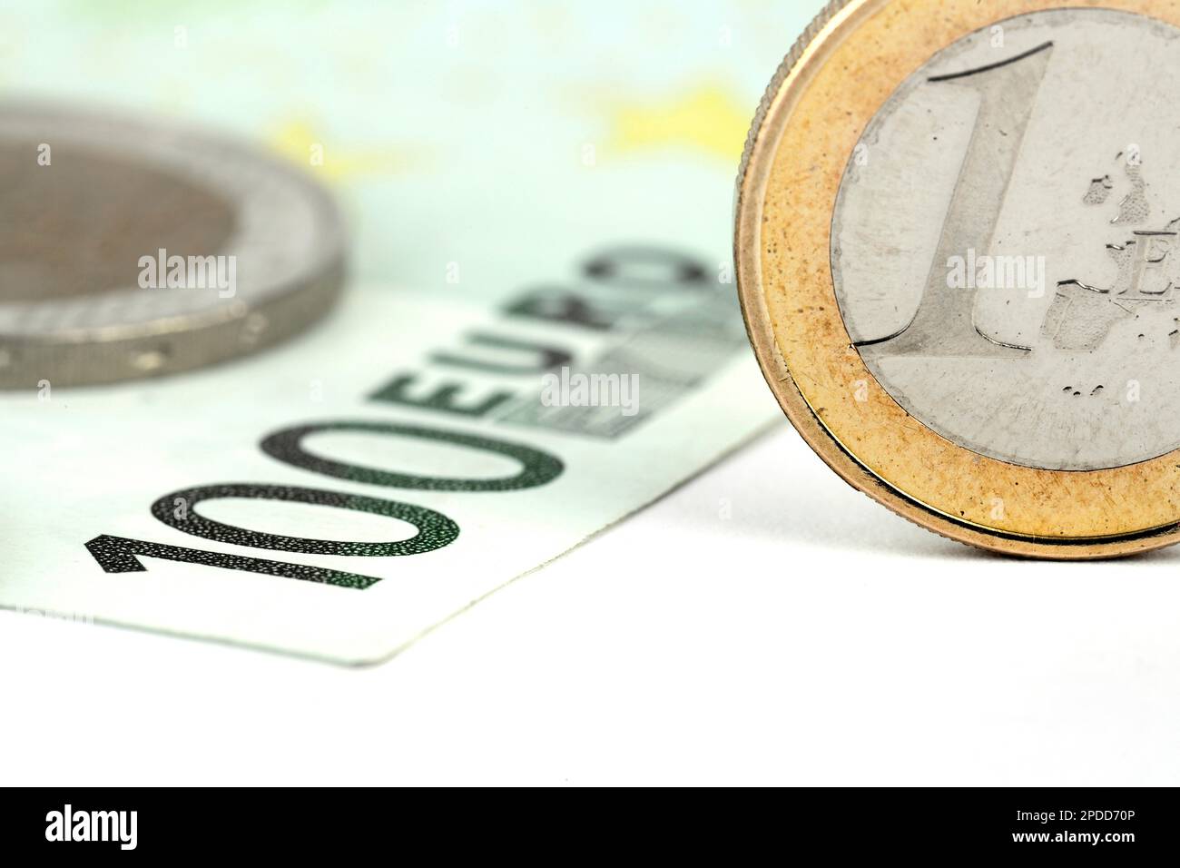 100 Euro bill with 1 Euro coins, cutout Stock Photo