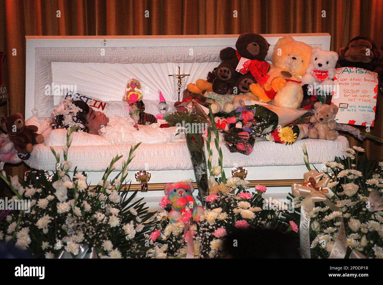 ** FILE ** Toys and flowers surround the coffin of 6 year old Elisa