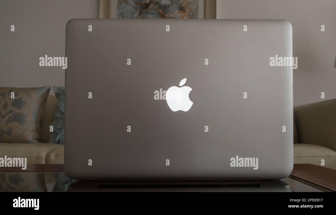 Apple logo on Apple Macintosh laptop computer cover in living room lounge Stock Photo