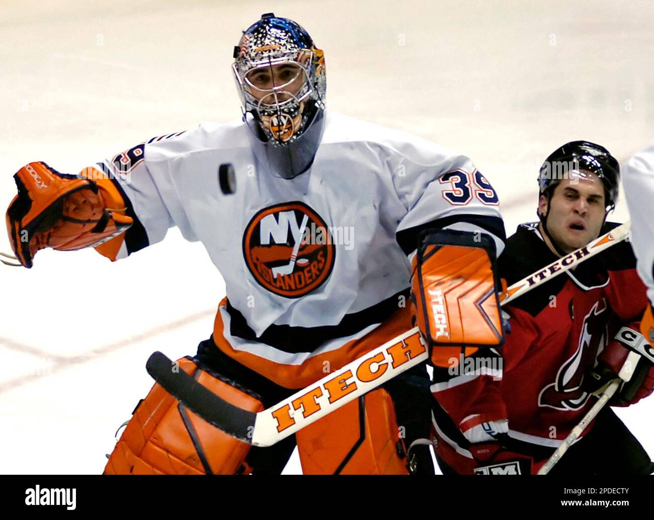 New Jersey Devils Brian Gionta right runs into New York Islanders goaltender Rick DiPietro as they eye the puck during second period NHL hockey Saturday Jan. 21 2006 in East Rutherford N.J
