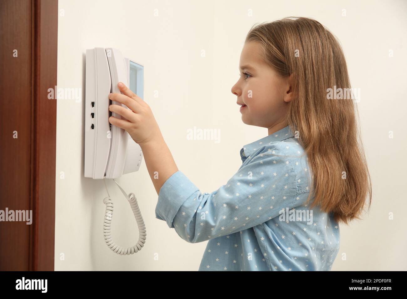 Cute little girl answering call indoors Stock Photo Alamy