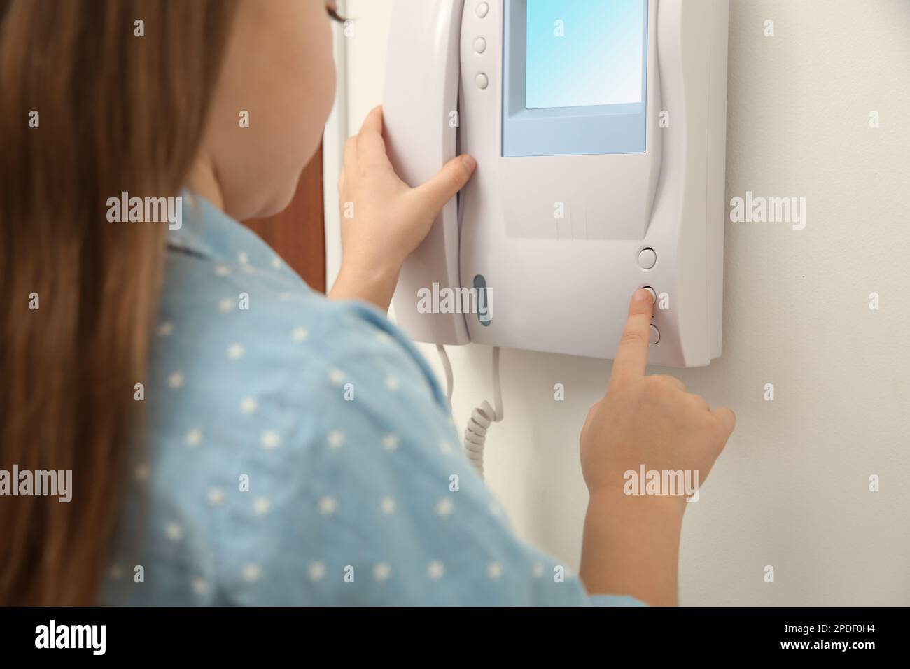 Cute little girl answering call indoors, closeup Stock Photo
