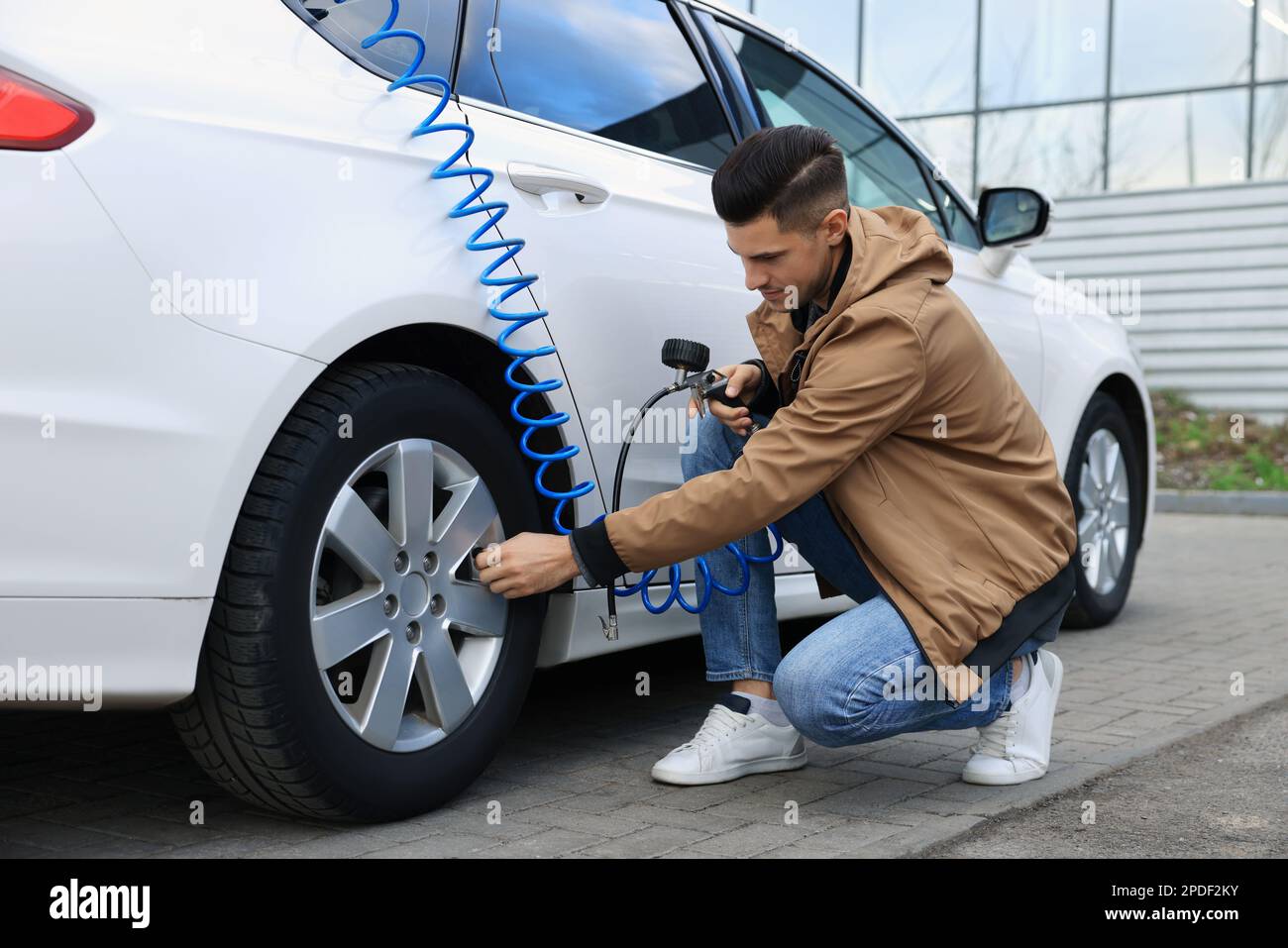 Handsome man inflating tire at car service Stock Photo Alamy