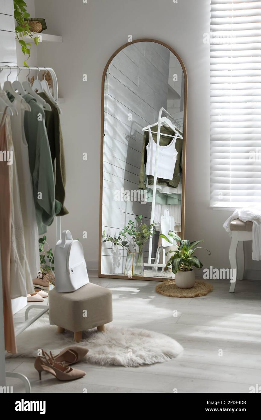 Rack with different stylish clothes, shoes and decorative elements in ...