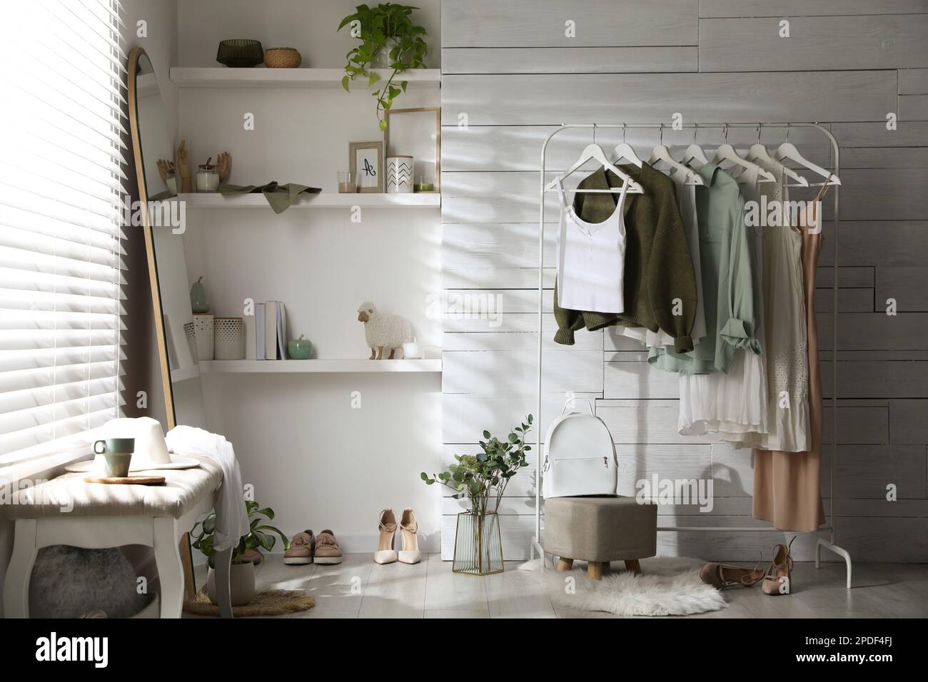 Rack with different stylish clothes, shoes and decorative elements in ...