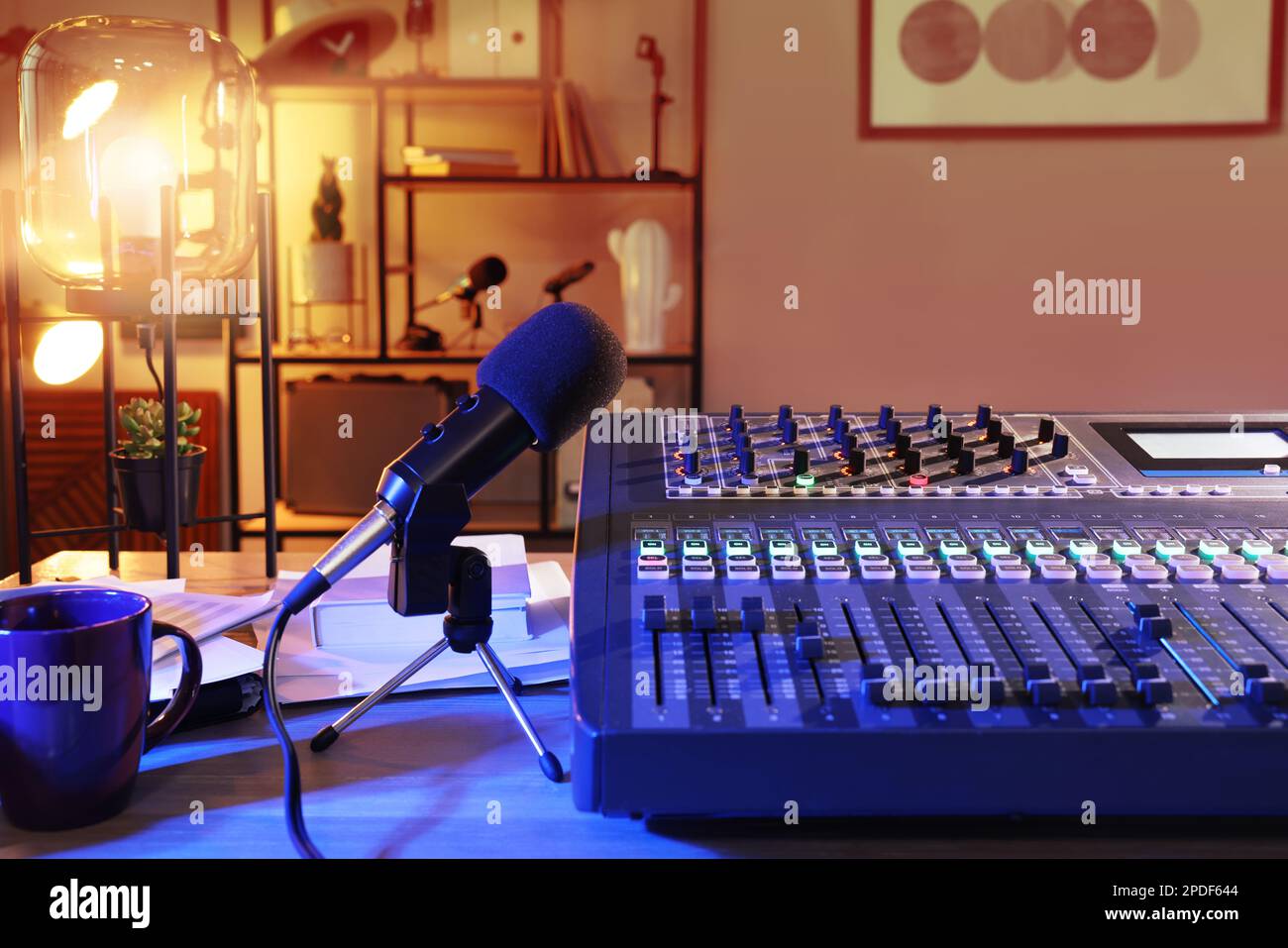 Microphone and professional mixing console on table in radio studio