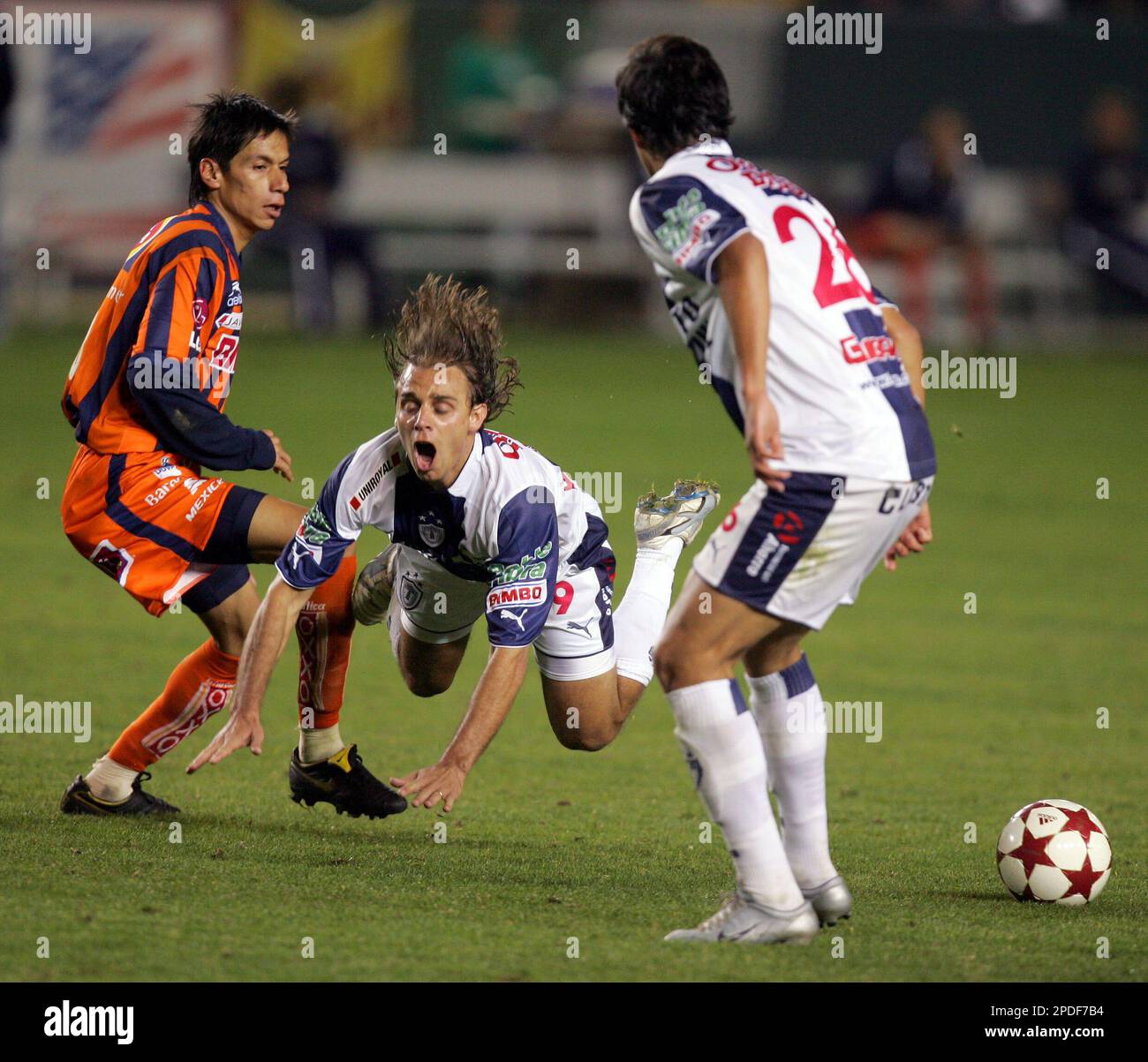 Pachuca's Richard Nunez, center, is tripped by Monterrey's Paulo Serafin, left, and Nunez's teammate Luis A. Landin looks on in the second half during their Interliga soccer game at the Home Depot Center Wednesday, Jan. 11, 2006, in Carson, Calif. (AP Photo/Chris Carlson) Stock Photo