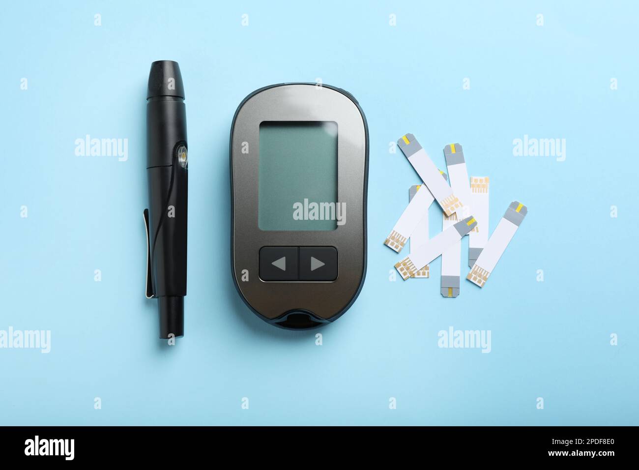 Digital lancet pen and test strips on light blue background