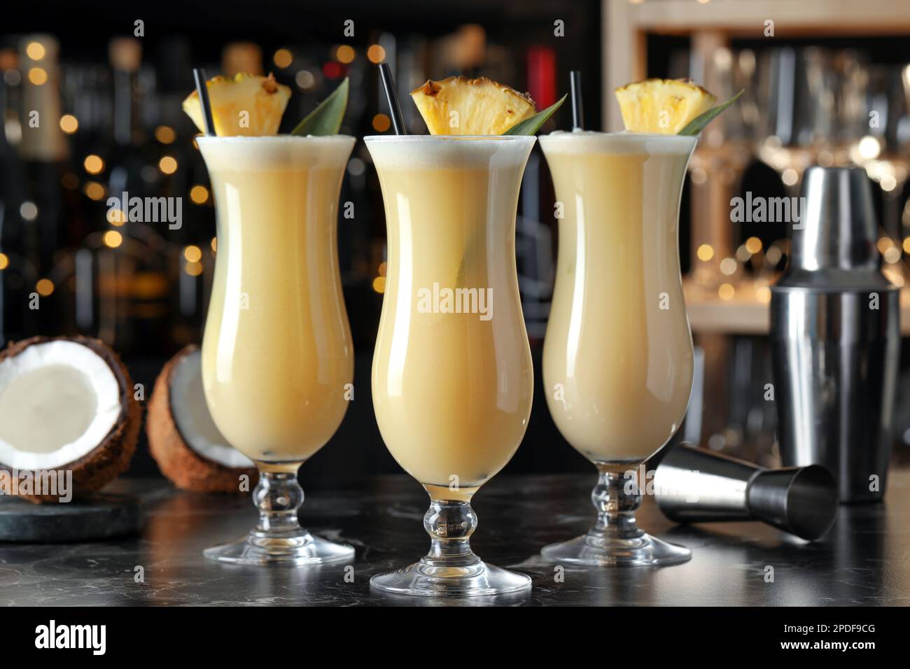 Tasty Pina Colada cocktails on black marble bar countertop Stock Photo