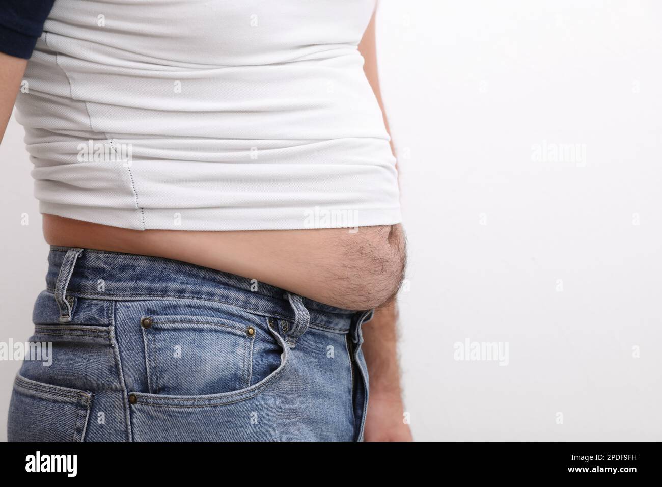 Man wearing tight t-shirt and jeans on white background, closeup ...