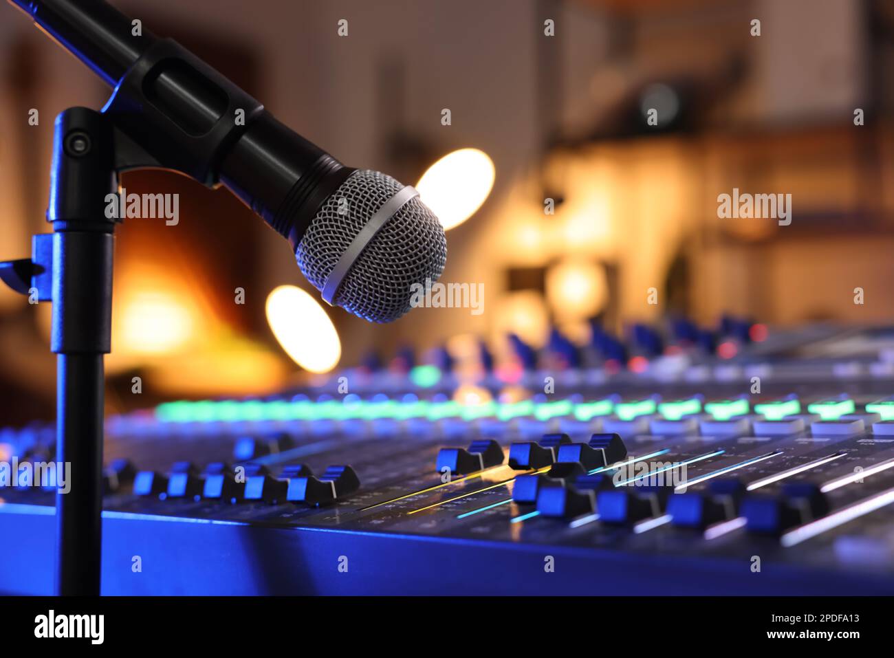 Microphone near professional mixing console in radio studio, closeup