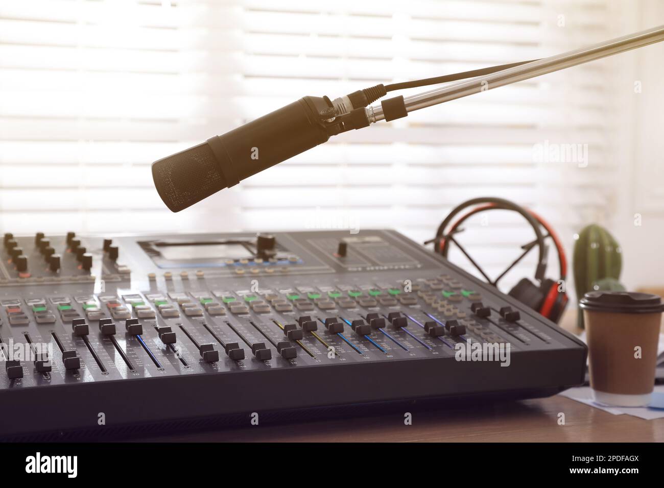 Microphone near professional mixing console in radio studio Stock Photo