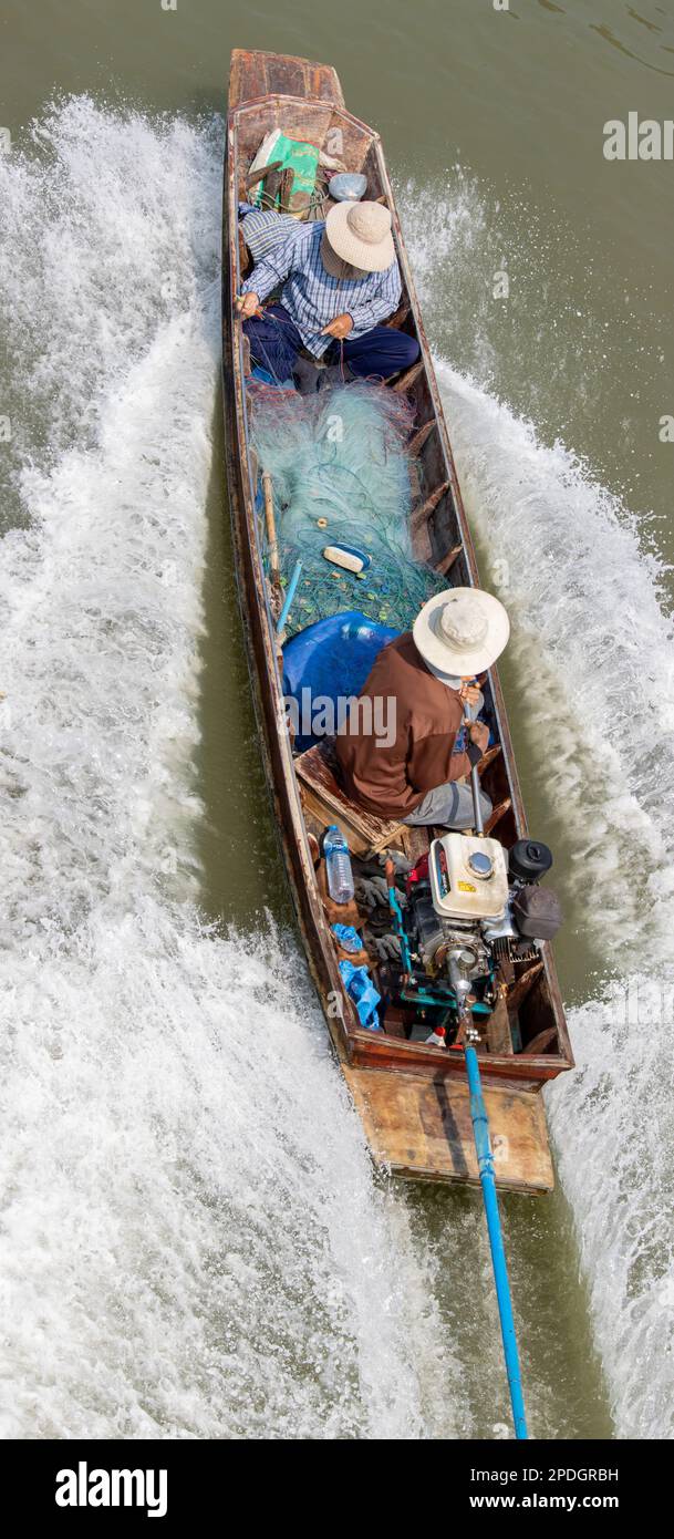 Fishermen sail on a boat with fishing nets, Thailand Stock Photo