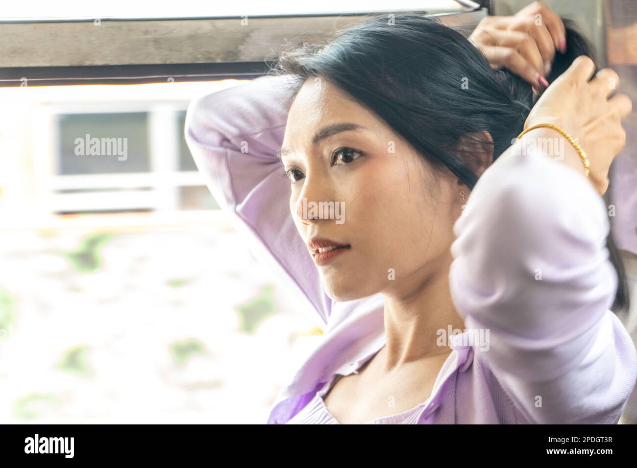 Portrait of a woman fixing her hair in a moving old bus Stock Photo