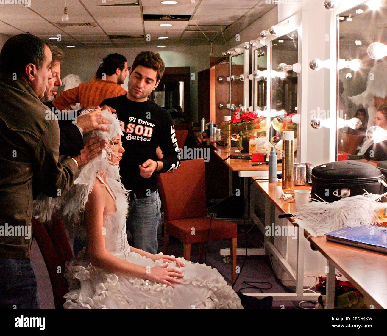A Lebanese hairdresser and his team put the final touches on a contestant's outfit in the Miss