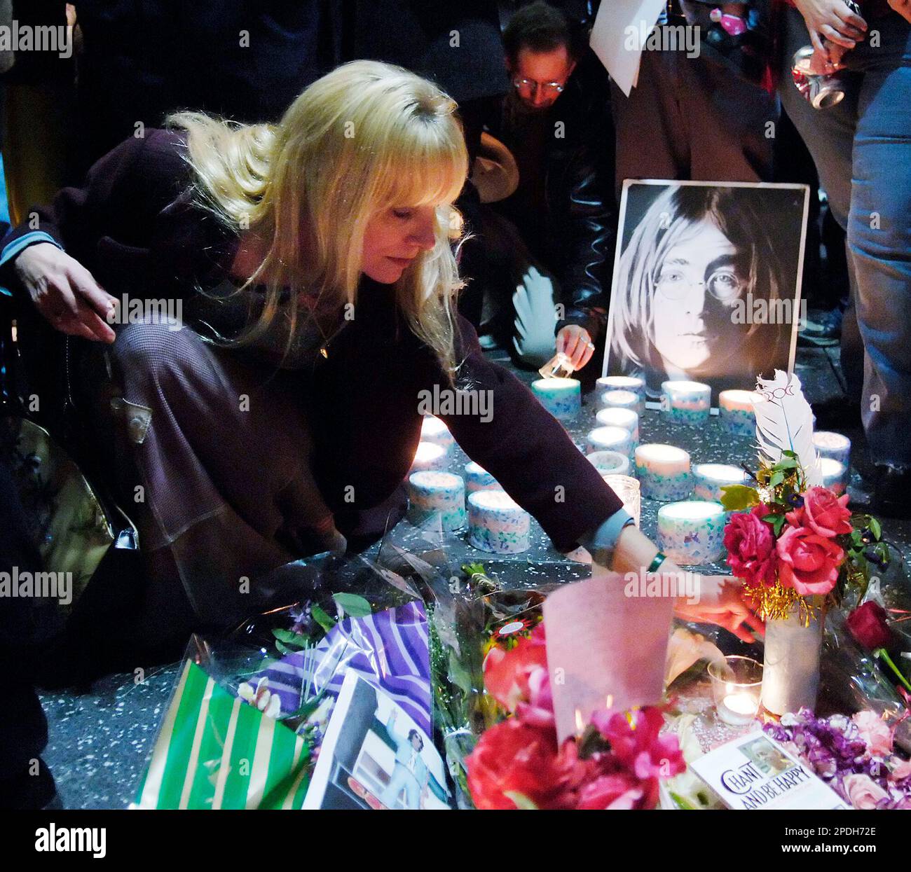 Candlelight vigil attendees put down candles and flowers on the