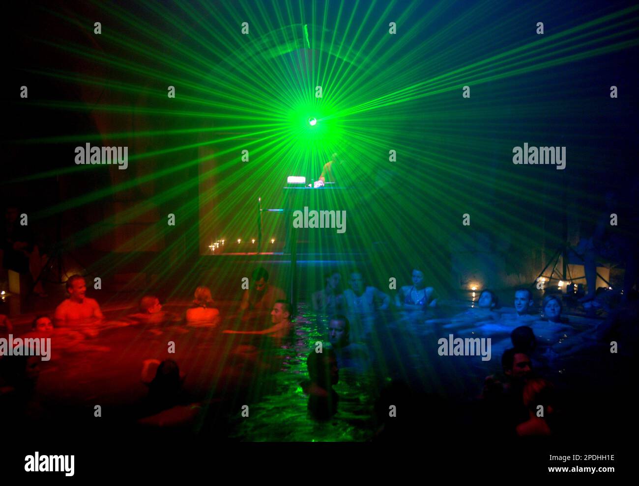 Under laser lights party goers relax in thermal waters during a rave style  party which combines music, film and performance, inside the Kiraly Bath in  Budapest, Hungary in the early morning hours