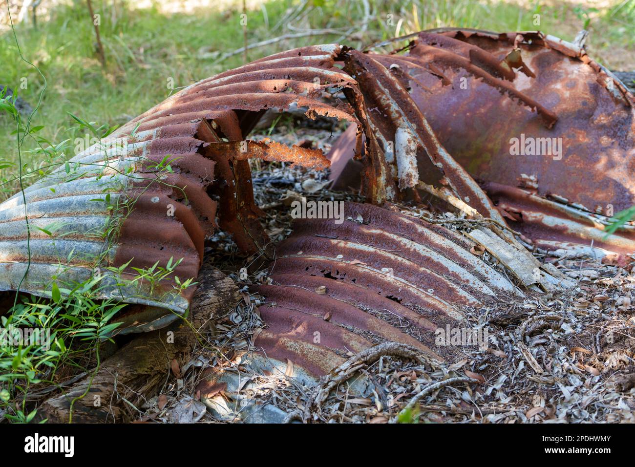Rusted and decayed, old corrugated iron watertank lying on the ground