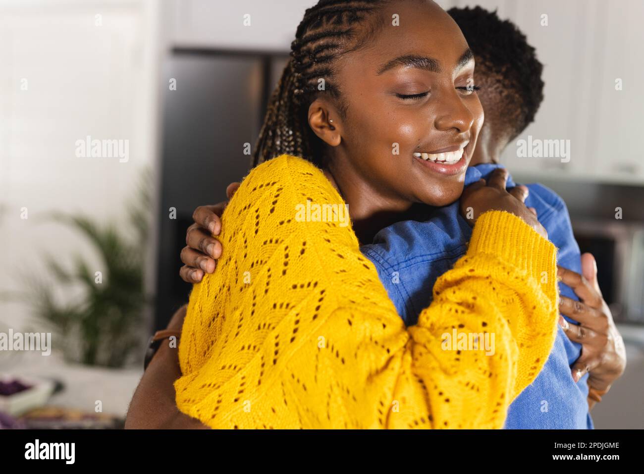 Happy african american couple embracing and smiling in kitchen Stock ...