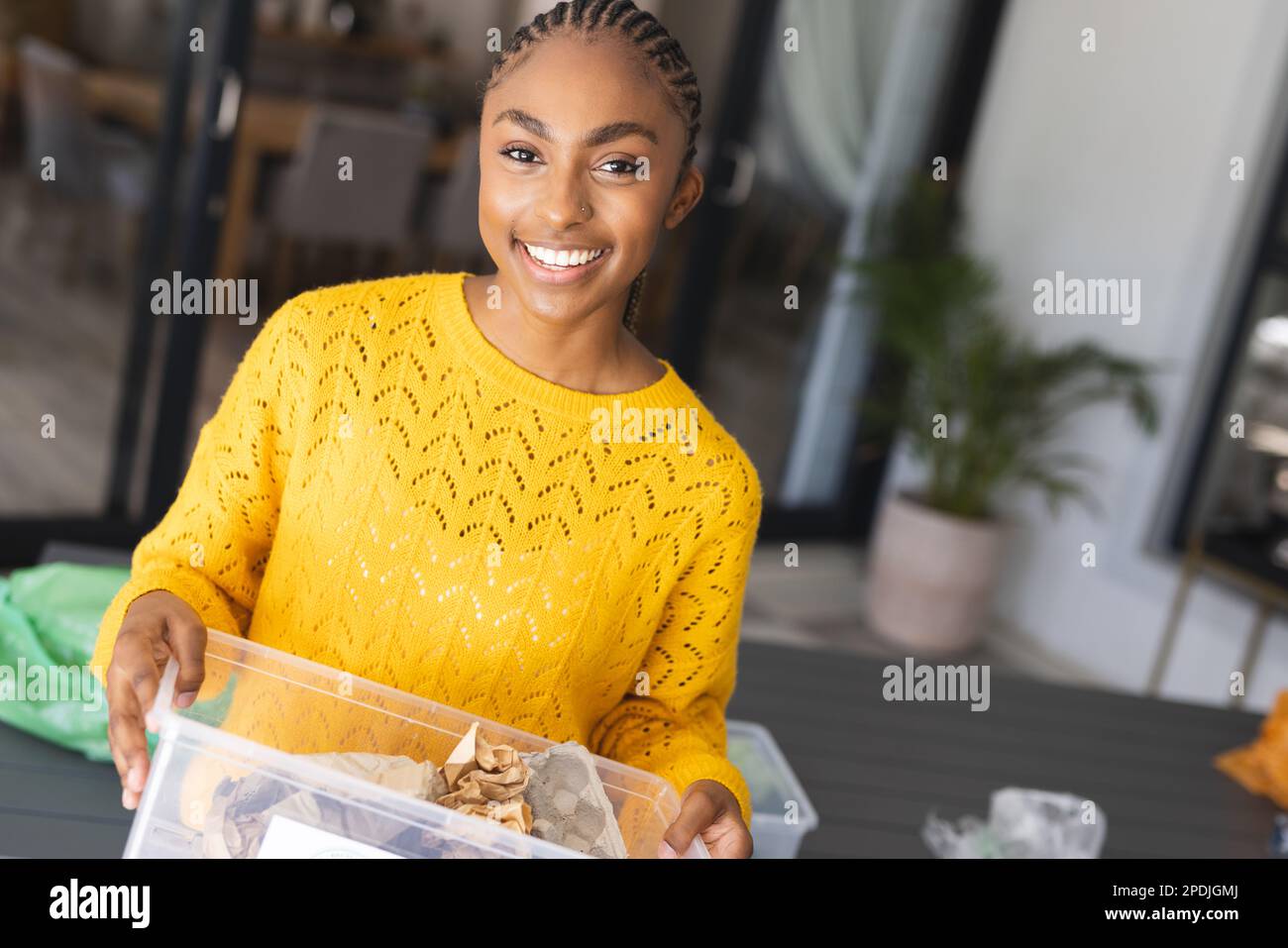 Portrait of happy african american woman holding recycling bin Stock Photo