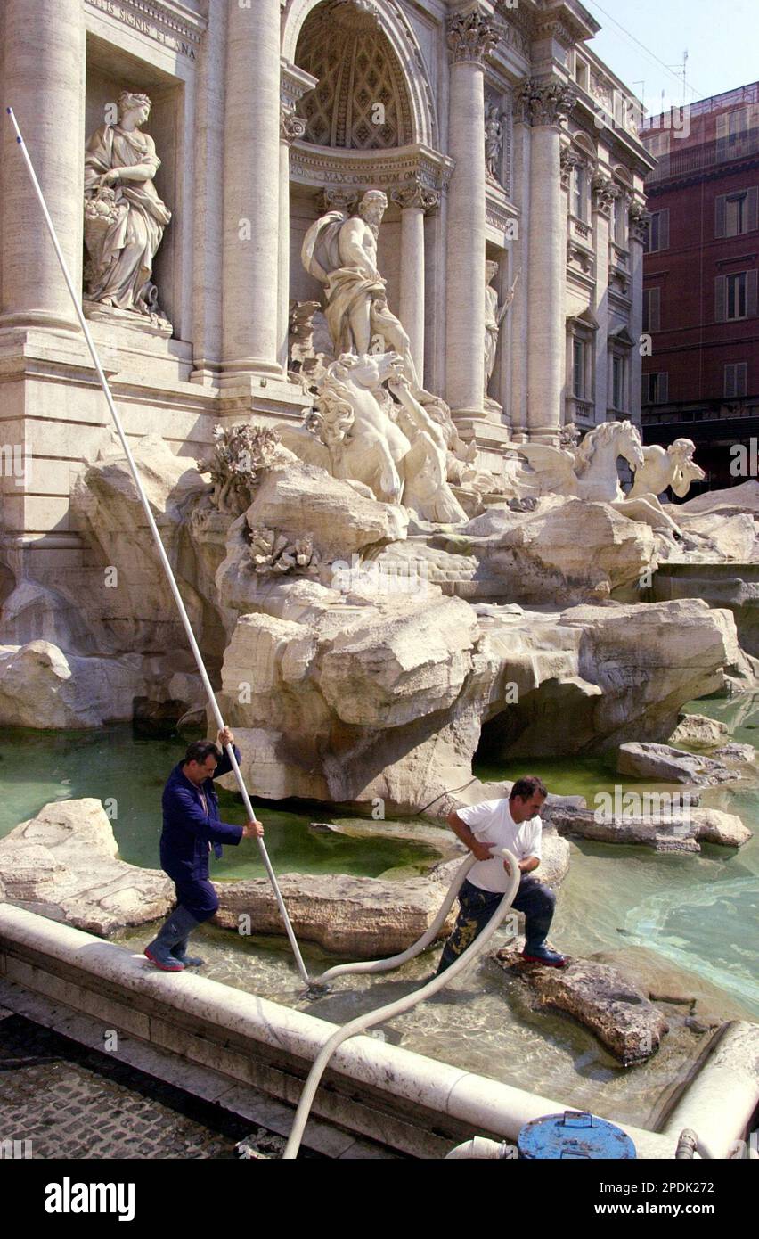 FILE Unidentified fountain cleaners siphon coins out of the