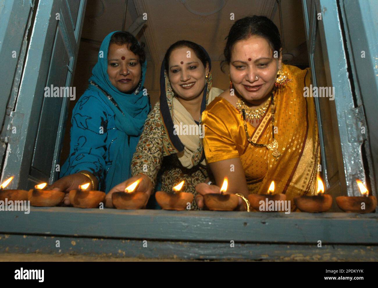 Hindu women living in Lahore, Pakistan light earthern lamps to celebrate the Hindu festival of