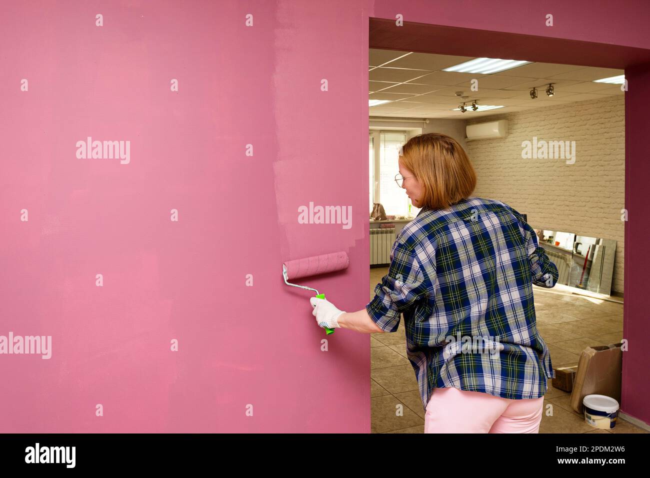 Wall and brush painter painting house wall with roller brush. Worker