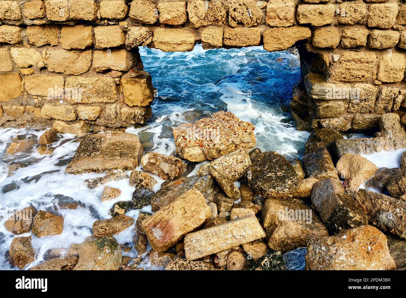 Ruins ancient city on Mediterranean coast. Ancient broken sandstone brick wall Stock Photo