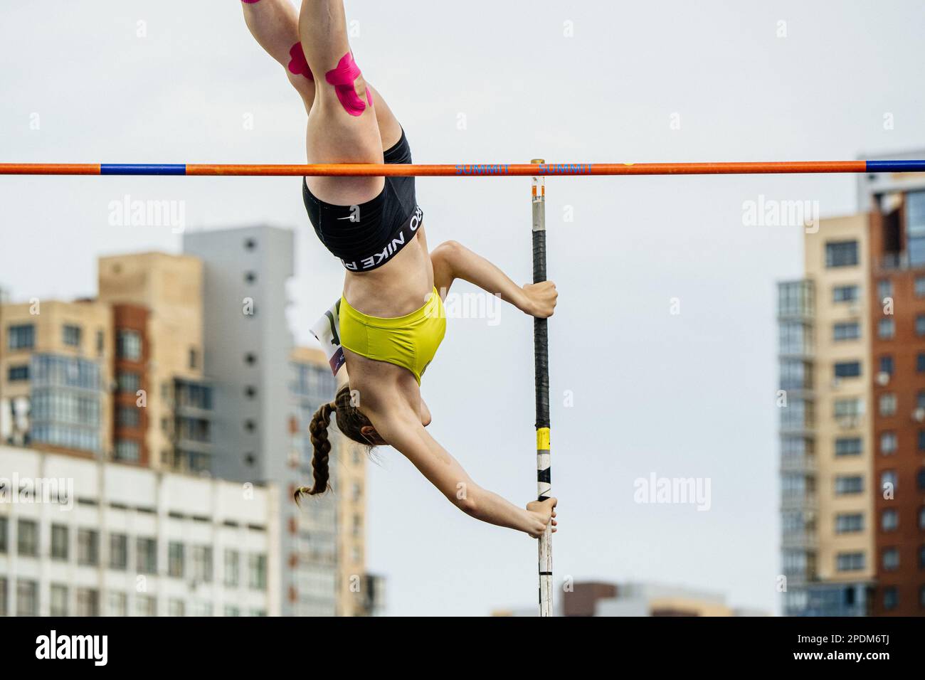 female athlete pole vault in sky background and building, summer sports