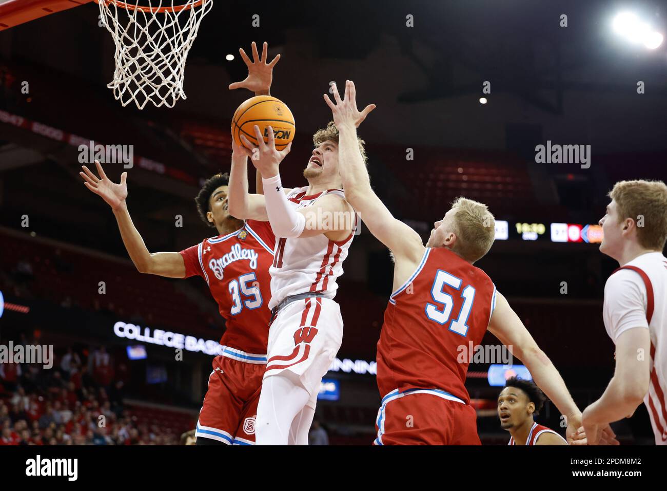 Madison, WI, USA. 14th Mar, 2023. Wisconsin Badgers guard Max Klesmit (11) makes a layup between Bradley Braves forward Darius Hannah (35) and forward Rienk Mast (51) during the NCAA basketball NIT First Round game between the Bradley Braves and the Wisconsin Badgers at the Kohl Center in Madison, WI. Darren Lee/CSM/Alamy Live News Stock Photo