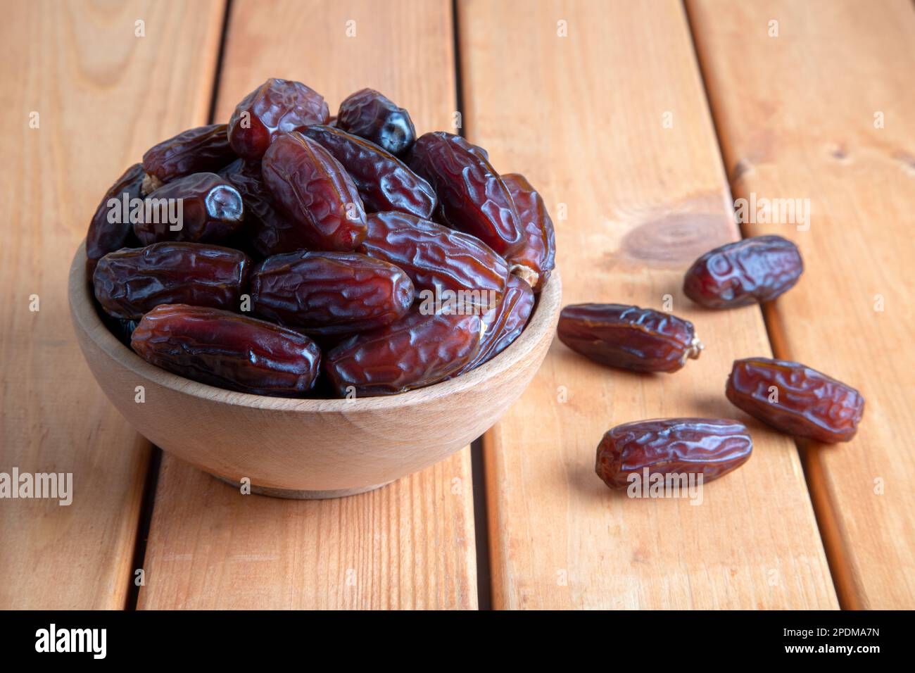 Date fruits in wooden bowl,on wooden table Stock Photo