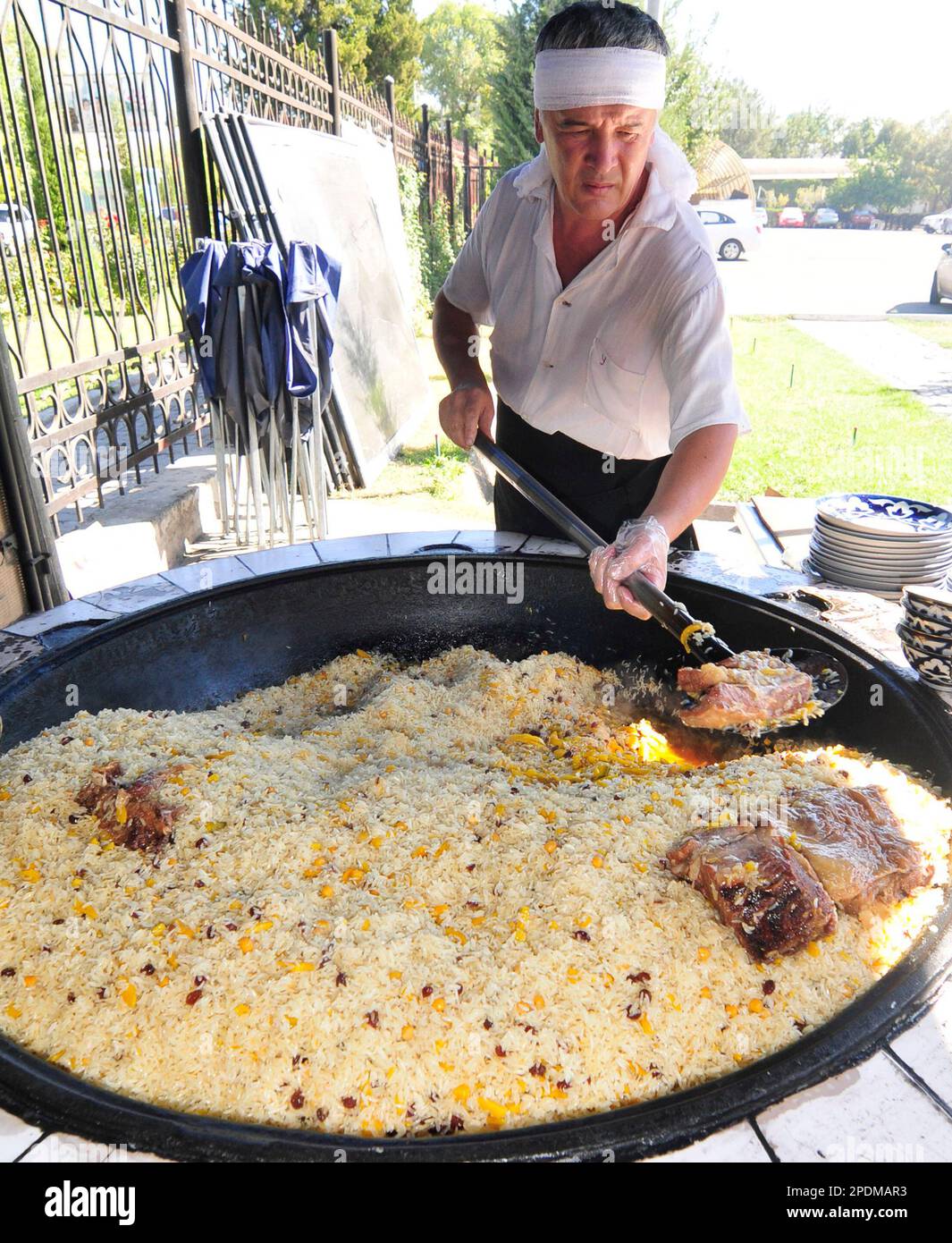 Giant cauldrons overflow with Uzbekistan's favorite rice dish at the Central Asian Plov center in Tashkent, Uzbekistan. Stock Photo