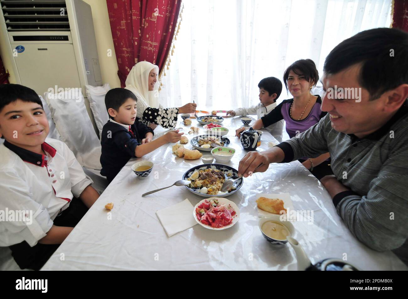 An Uzbek family enjoying a traditional Plov at the Central Asian Plov center in Tashkent, Uzbekistan. Stock Photo