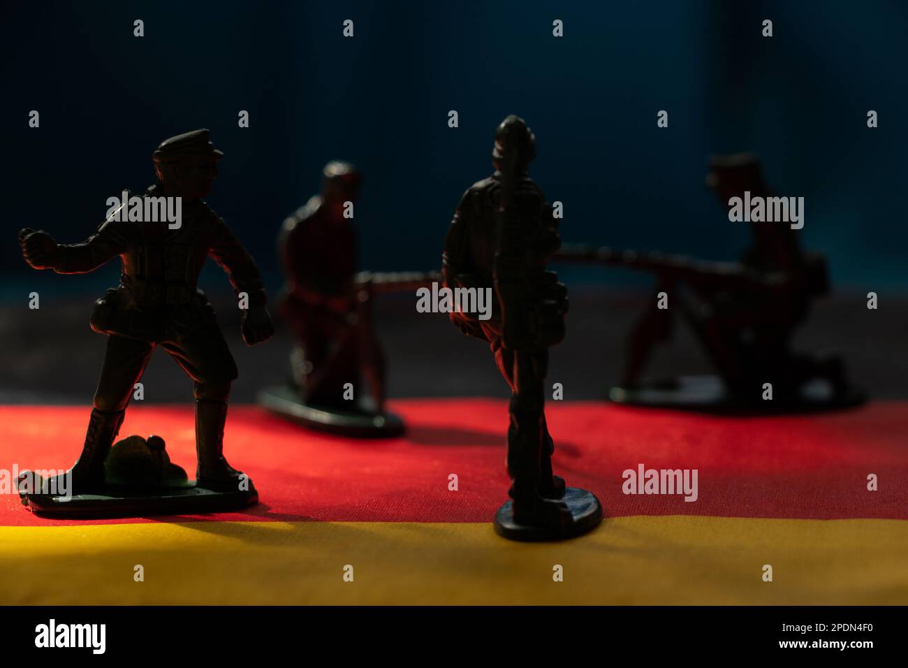Small plastic soldiers stand on the flags of Germany close-up, army and war Stock Photo