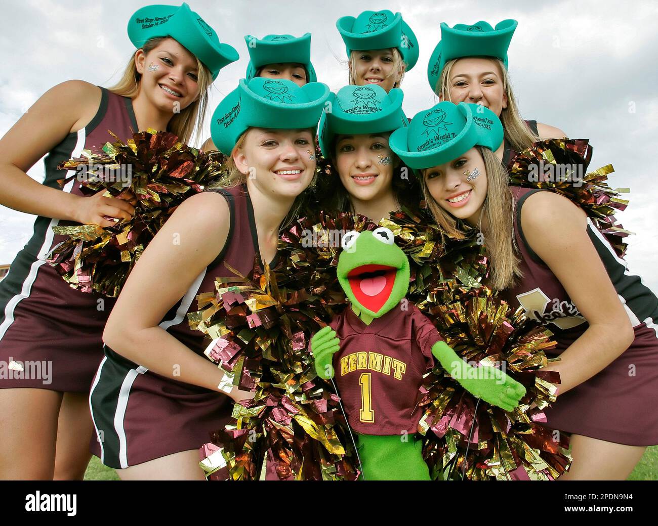 The Kermit High School varsity cheerleaders surround Kermit the Frog