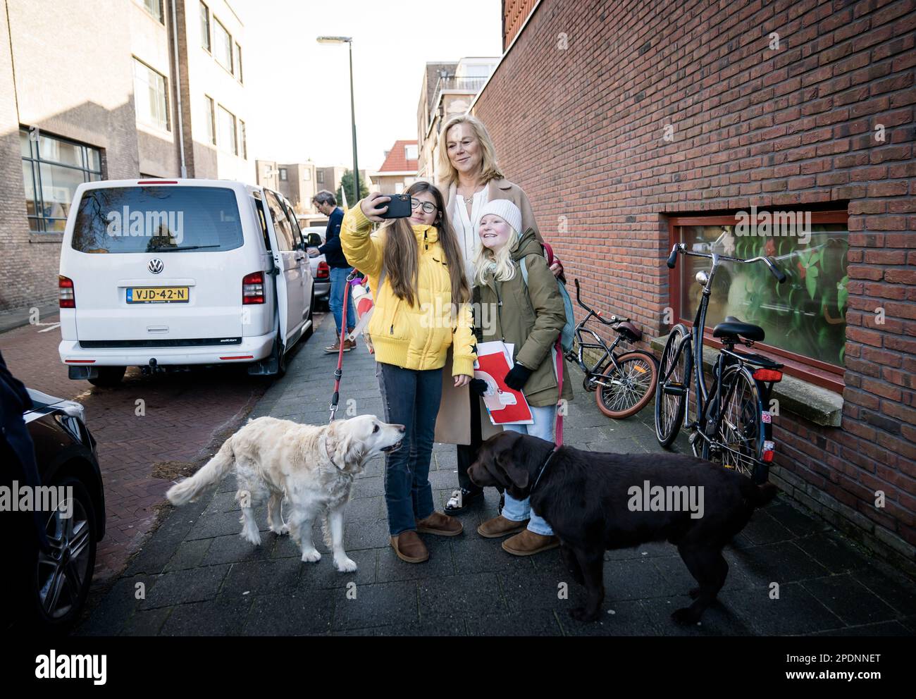 THE HAGUE - Children take a selfie with D66 leader Sigrid Kaag and her dogs Goldie and Marjo, after she cast her vote for the Provincial Council elections and the Water Board elections. ANP BART MAAT netherlands out - belgium out Stock Photo