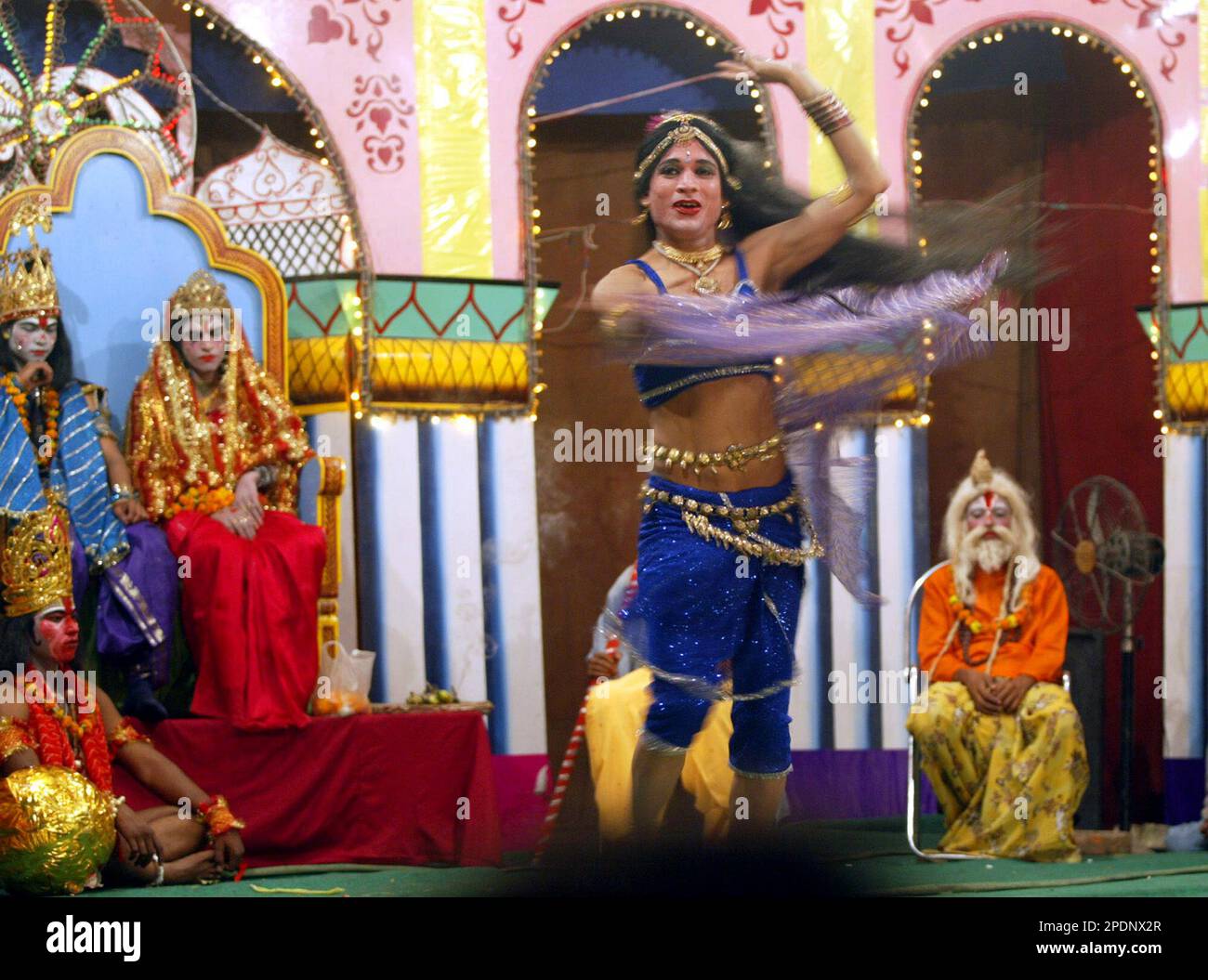 An artist dances as others dressed as Hindu God Rama, seated left on ...