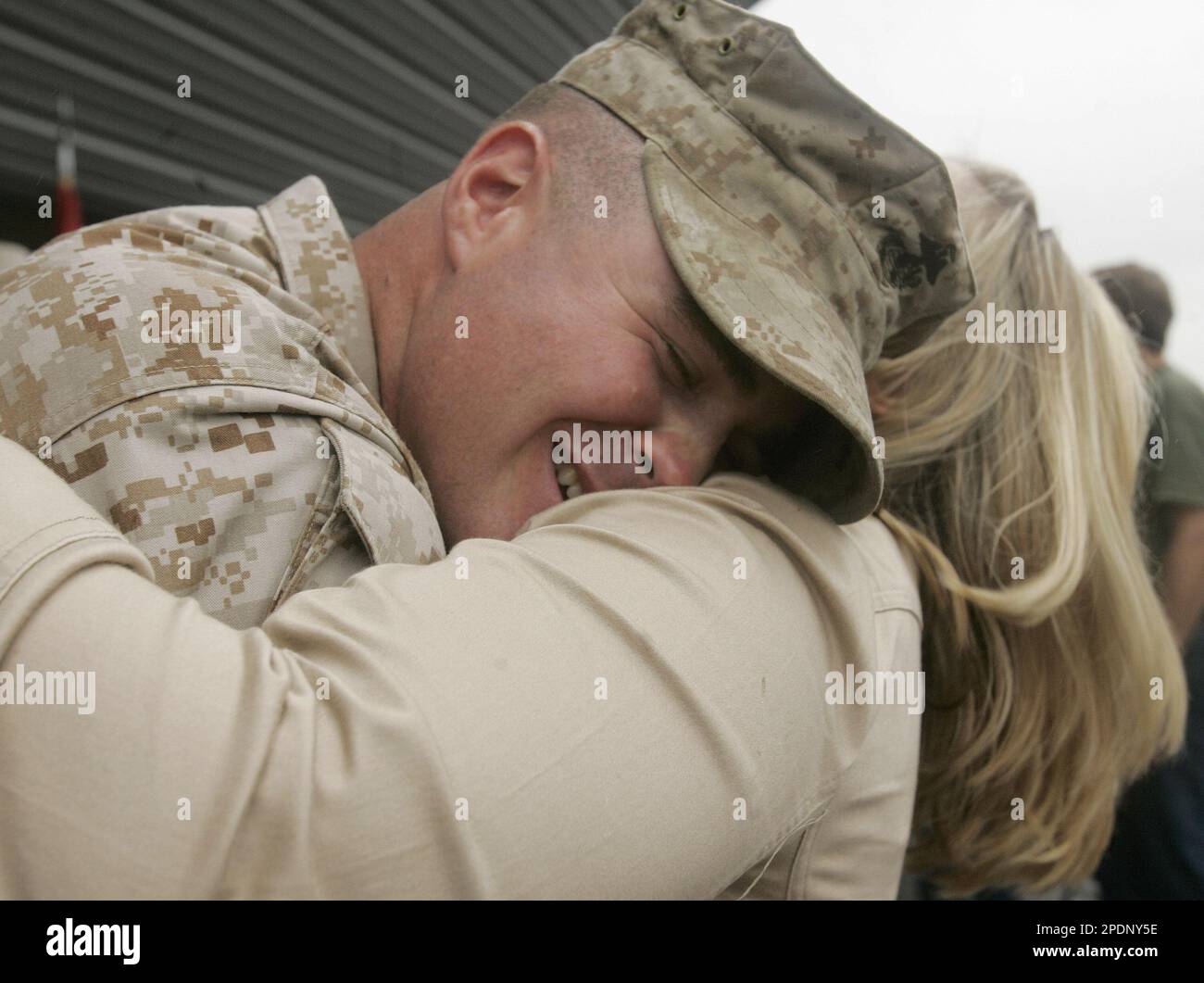 Marine Sgt. Alex Rozanski from Columbus, Ohio, left, hugs his fiancee ...