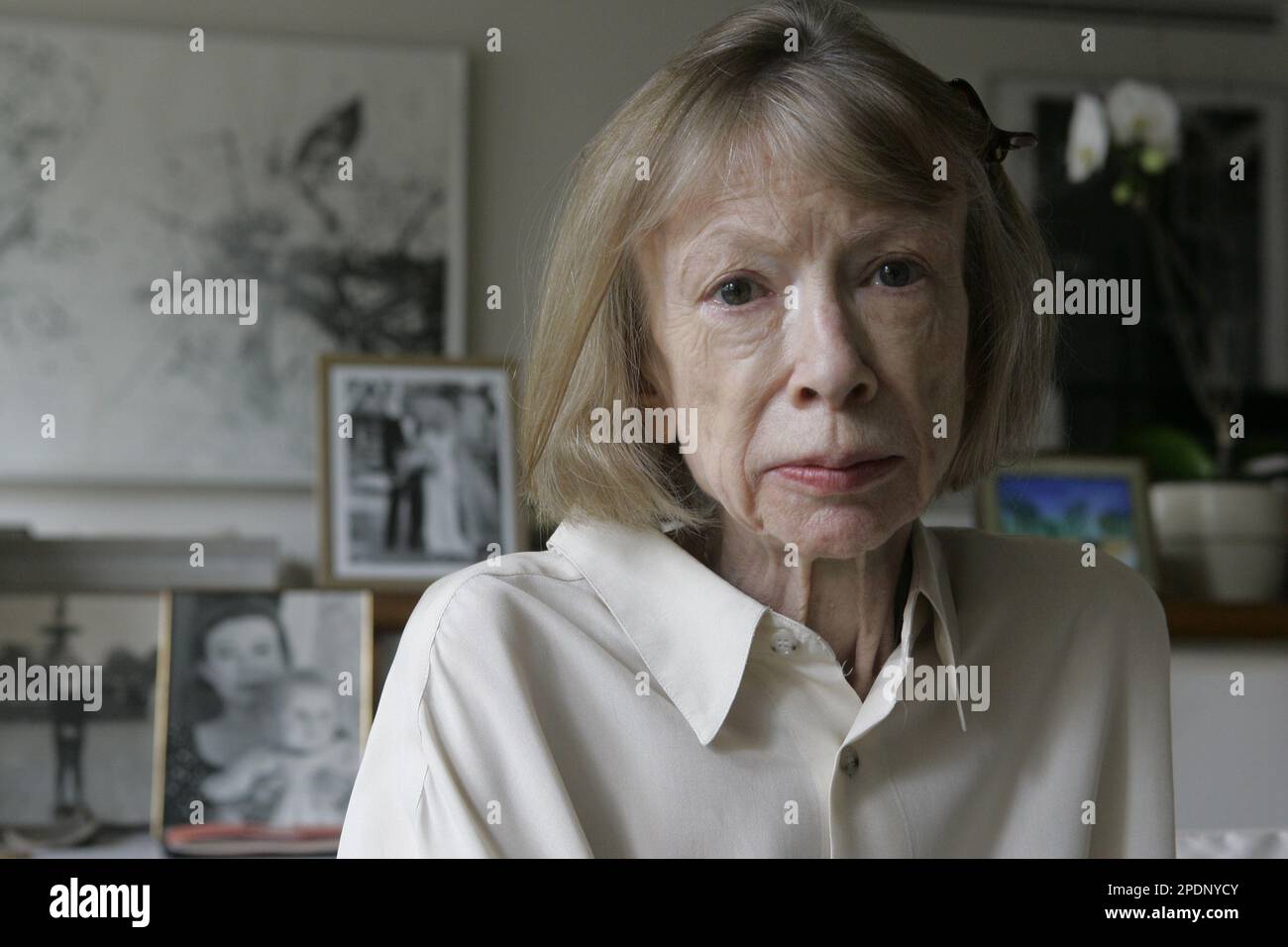 Author Joan Didion sits in front of a photo of herself holding her  daughter, Quintana Roo, and another picture of her daughter's wedding, in  her New York apartment Sept. 26, 2005. Didion's, image size:1300x956