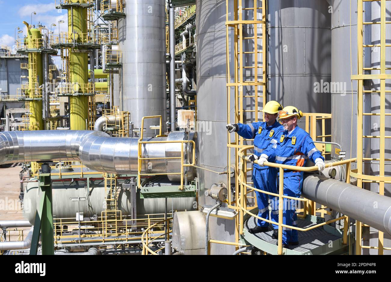 group of industrial workers in a refinery oil processing equipment