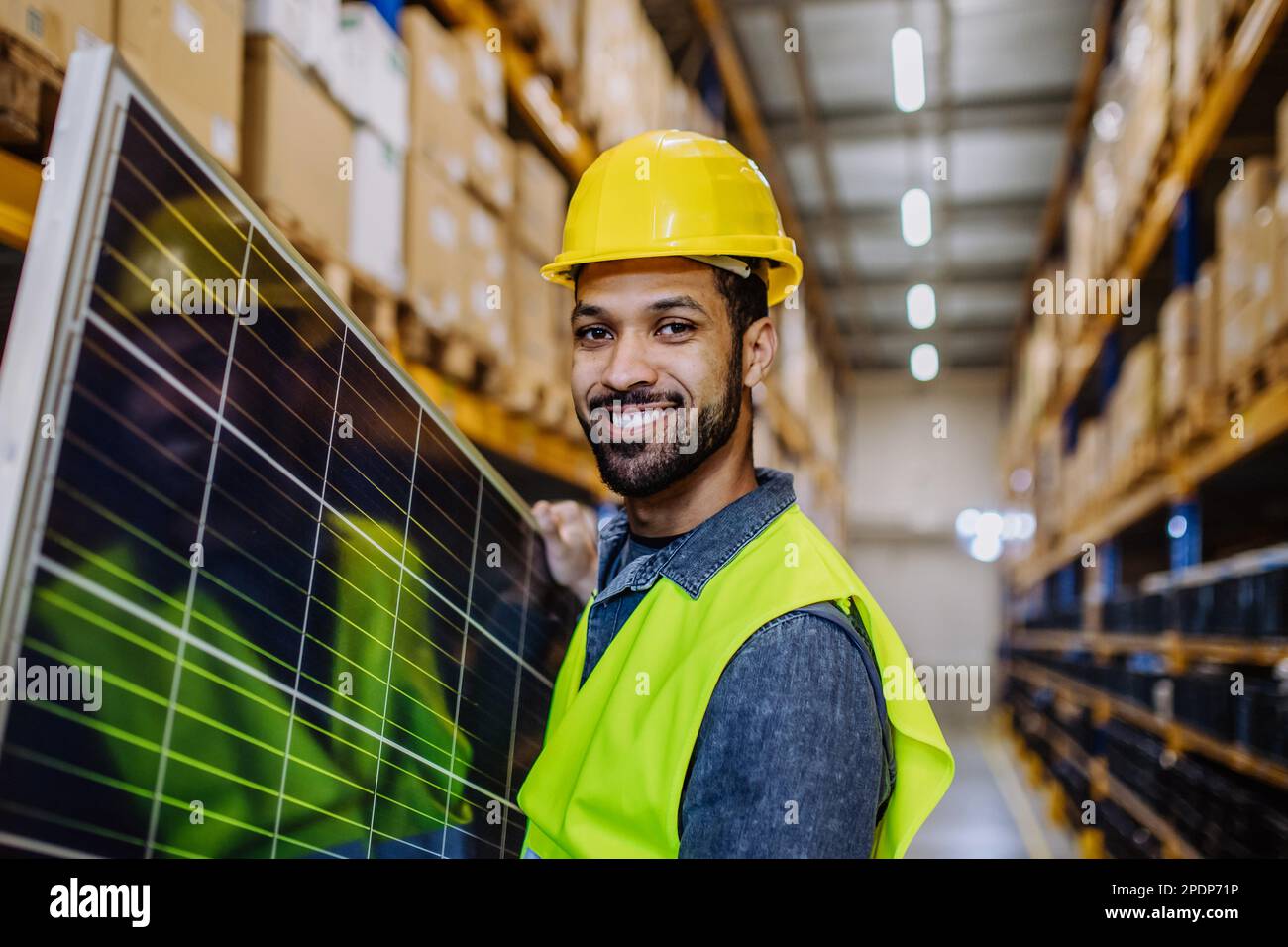 Smiling warehouse worker carring a solar panel Stock Photo Alamy