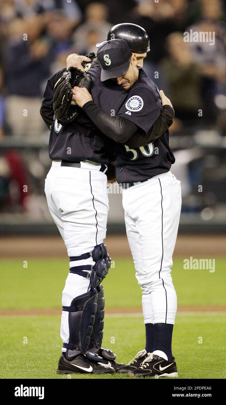 Seattle Mariners catcher Dan Wilson, left, is hugged by pitcher Jamie Moyer  after Wilson was relieved at the plate just before the top of the second  inning, Friday, Sept. 30, 2005, in
