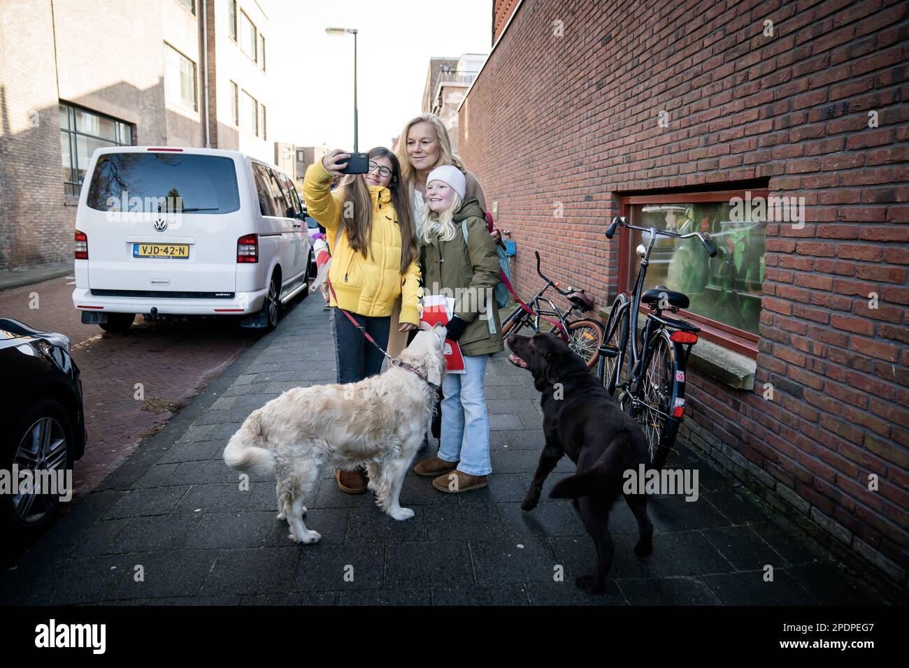 THE HAGUE - Children take a selfie with D66 leader Sigrid Kaag and her dogs Goldie and Marjo, after she cast her vote for the Provincial Council elections and the Water Board elections. ANP BART MAAT netherlands out - belgium out Stock Photo